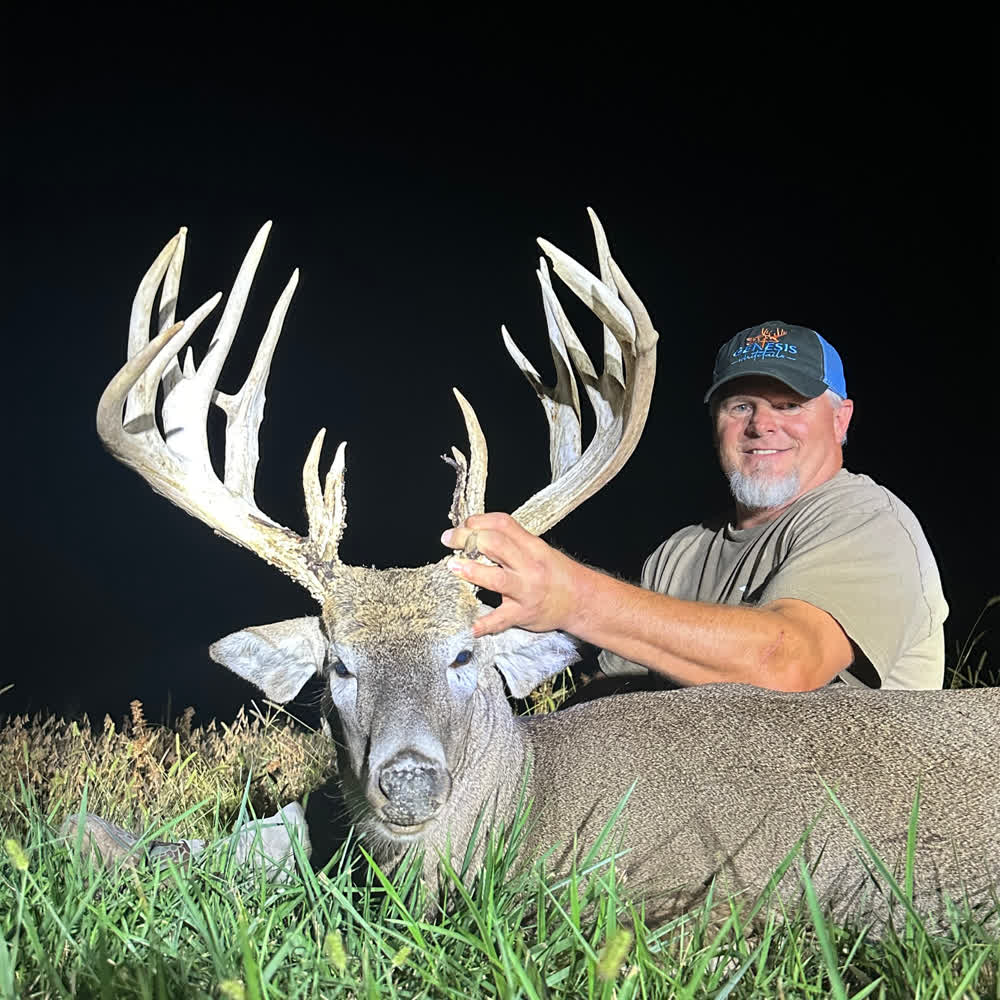 Russell with the giant whitetail buck he harvested at Genesis Whitetails